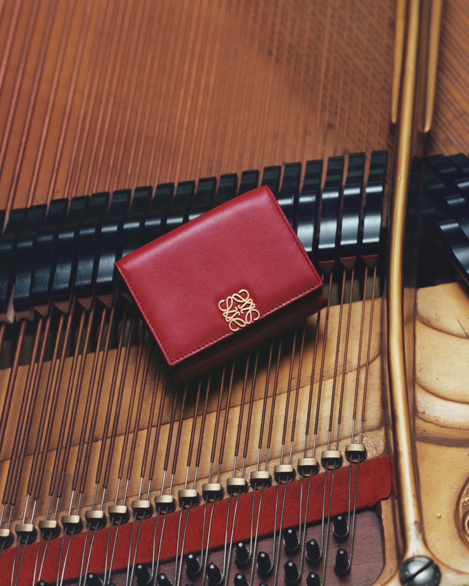 Loewe SS25 Online Stories red wallet on piano